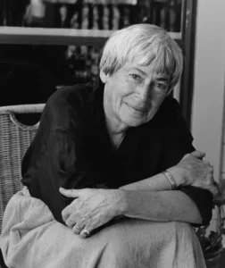 Retrato en blanco y negro de la escritora Ursula K. Le Guin, sentada y con los brazos cruzados, en 1995.
